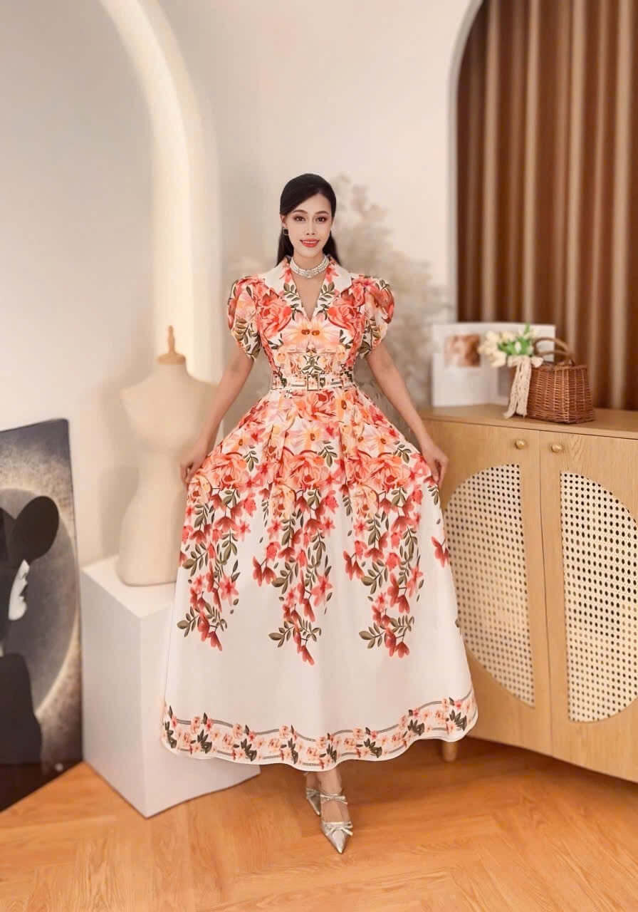 Model wearing Vietnamese Baroque maxi dress mango silk with floral pattern, posing in elegant room setting.